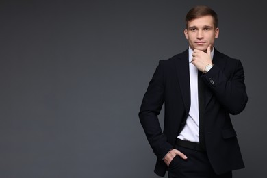 Man in classic suit with stylish watch on grey background. Space for text