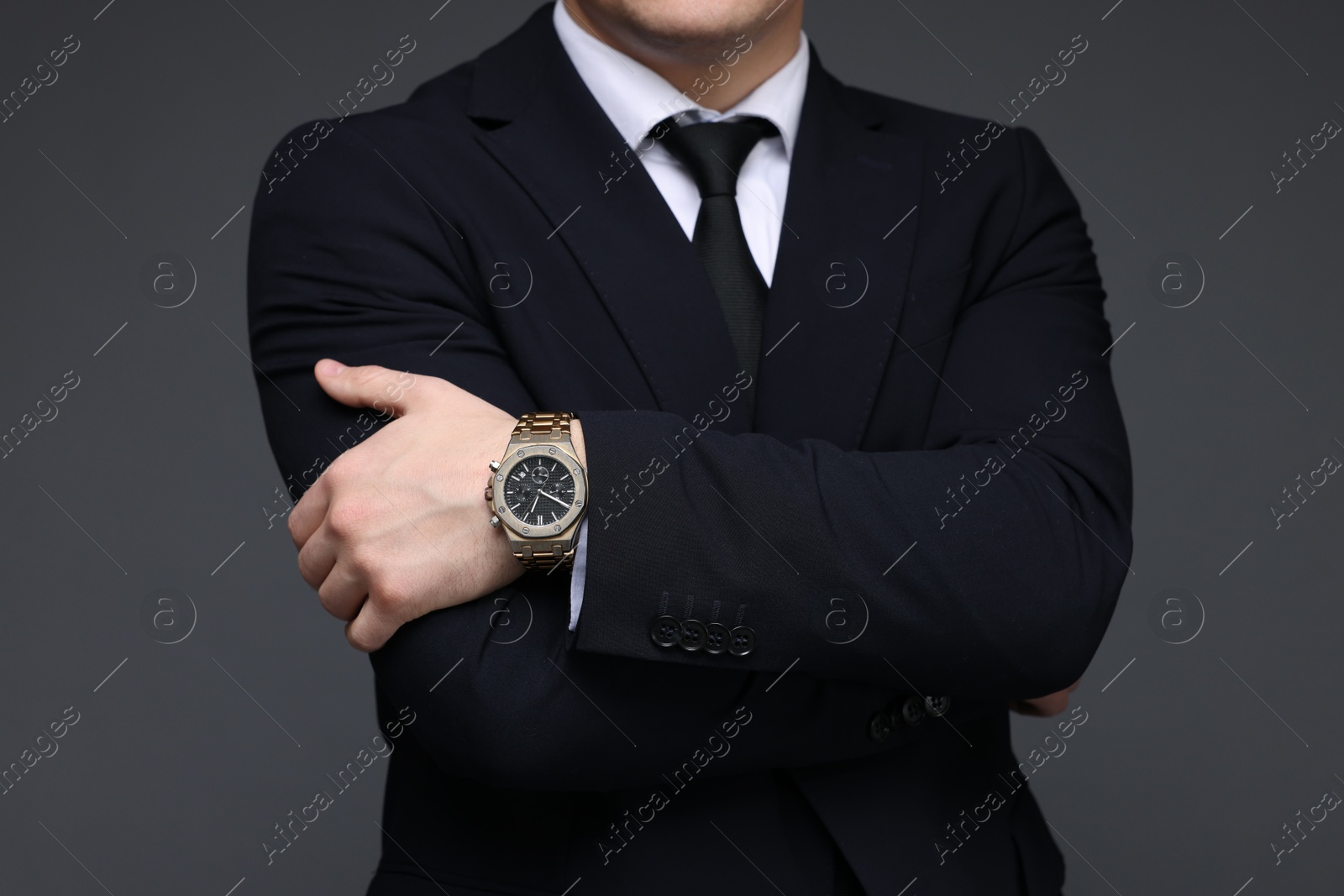 Photo of Man in classic suit with stylish watch on grey background, closeup