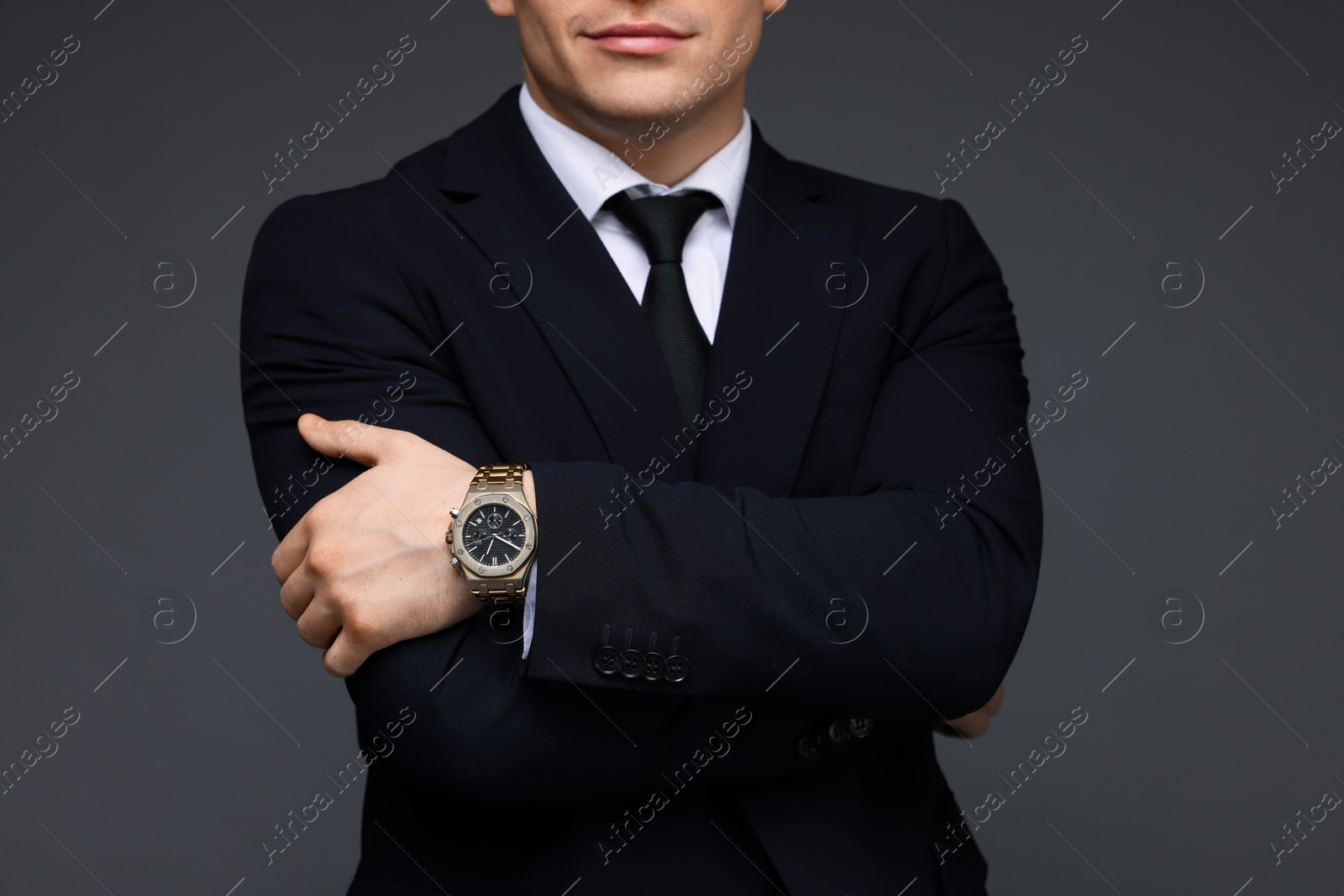 Photo of Man in classic suit with stylish watch on grey background, closeup