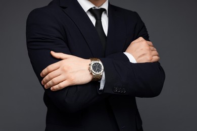 Photo of Man in classic suit with stylish watch on grey background, closeup