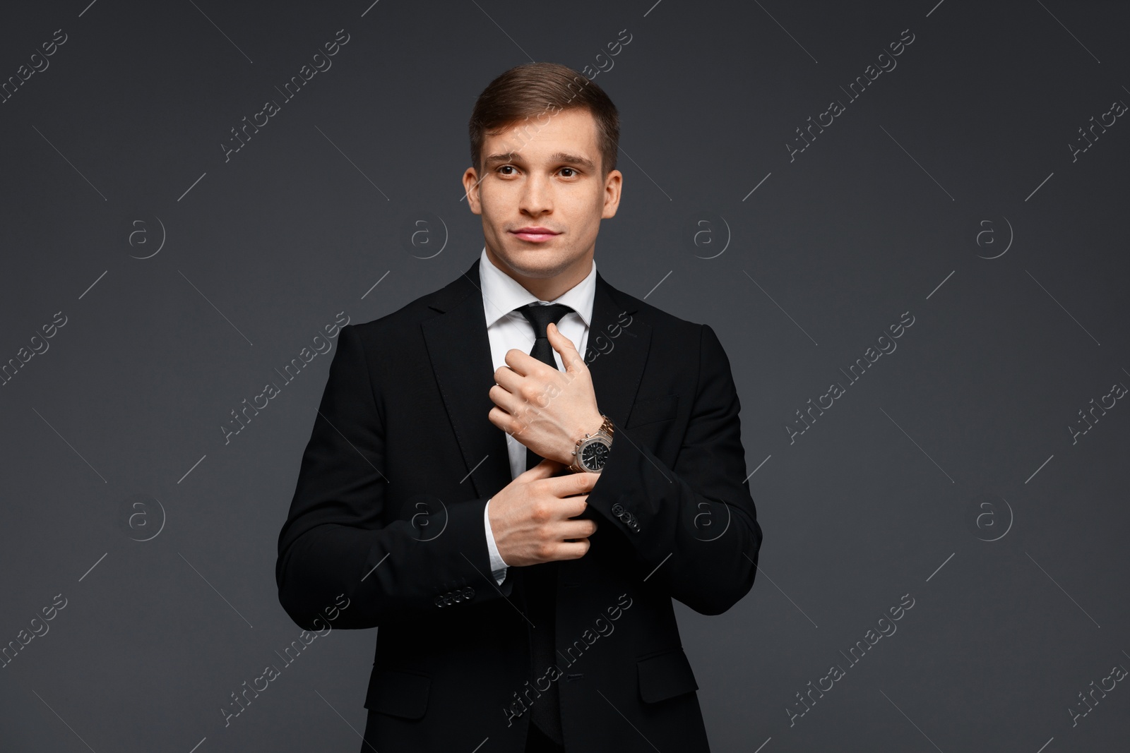 Photo of Man in classic suit with stylish watch on grey background