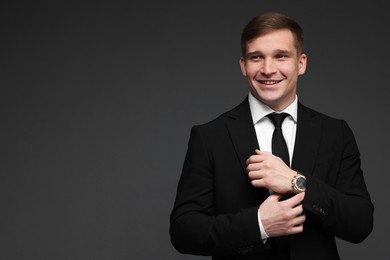 Photo of Man in classic suit with stylish watch on grey background. Space for text