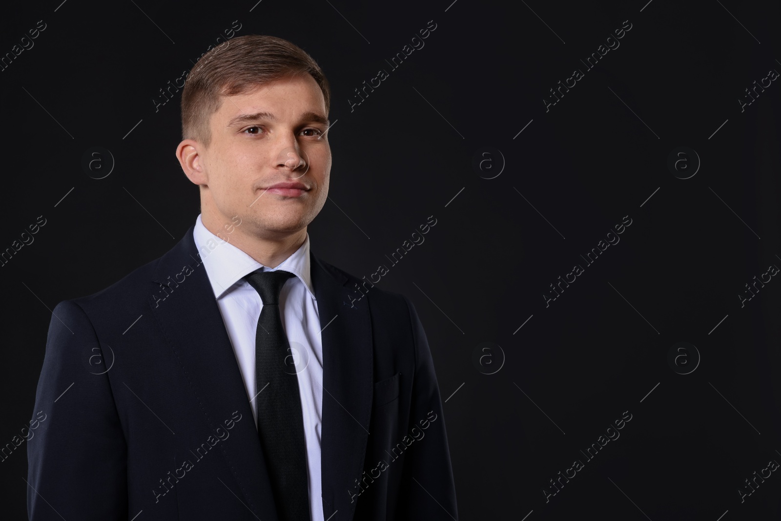 Photo of Man in classic suit on black background. Space for text