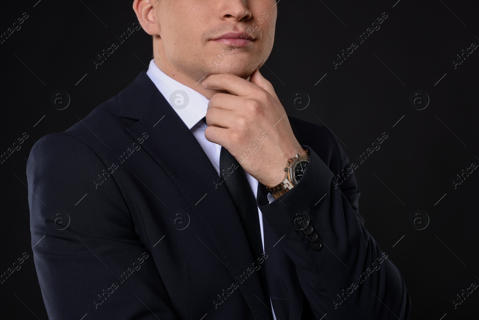 Photo of Man in classic suit on black background, closeup