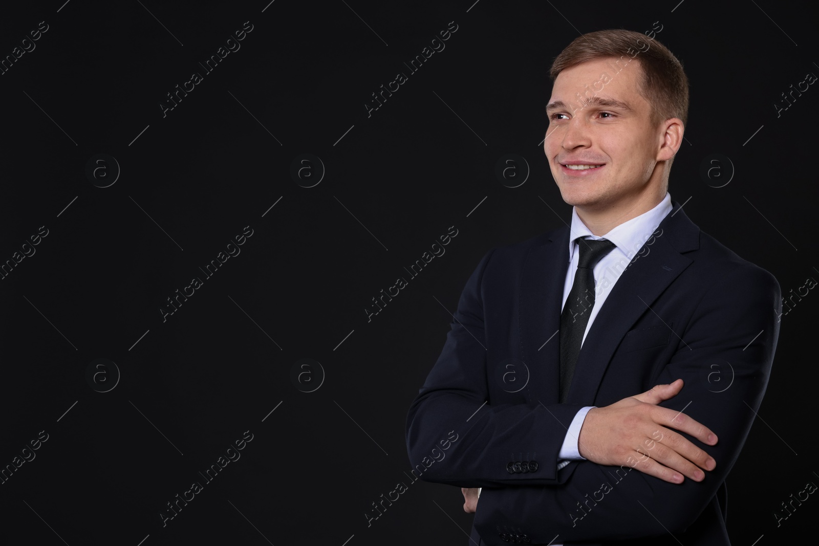 Photo of Man in classic suit on black background. Space for text