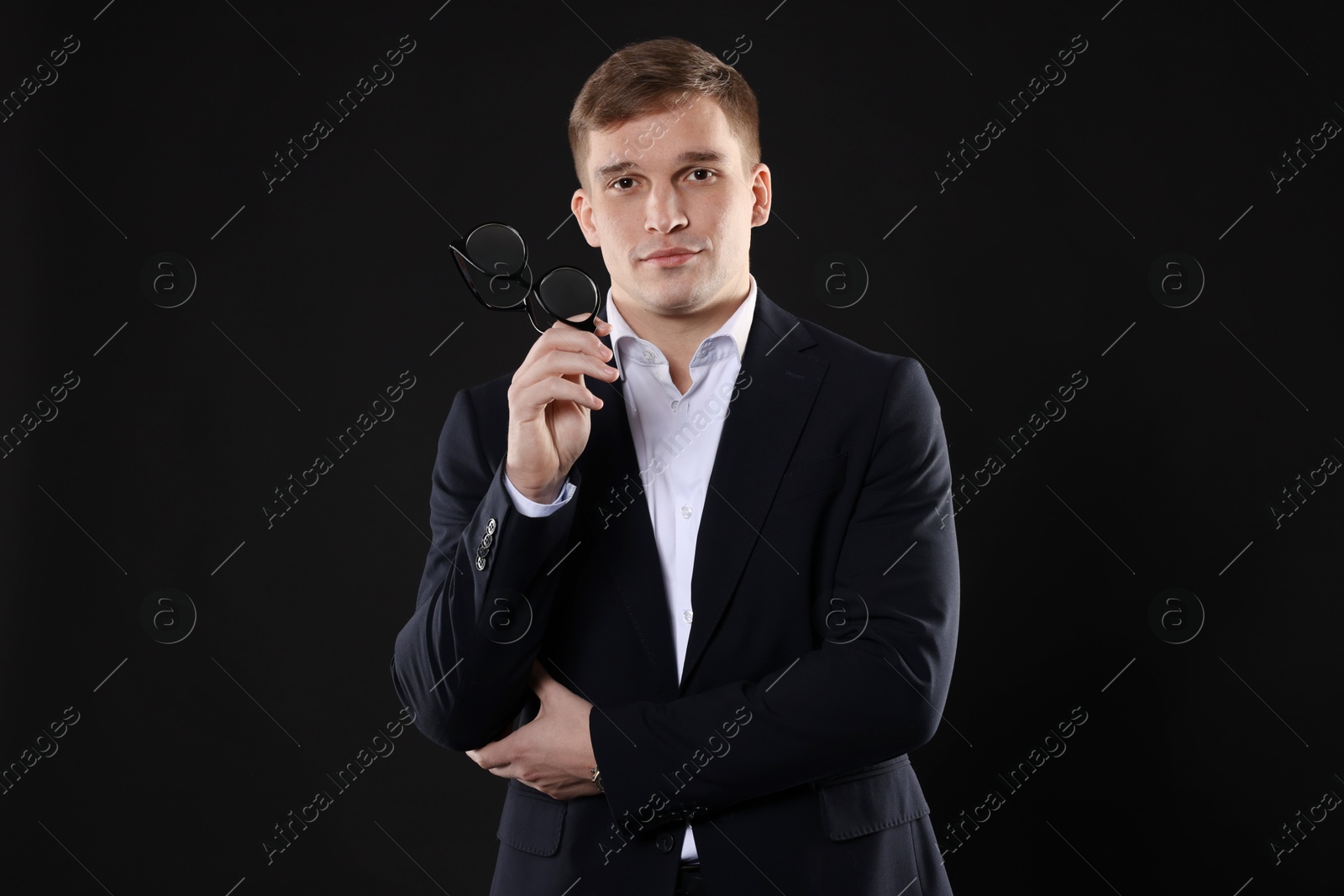 Photo of Man in classic suit with glasses on black background