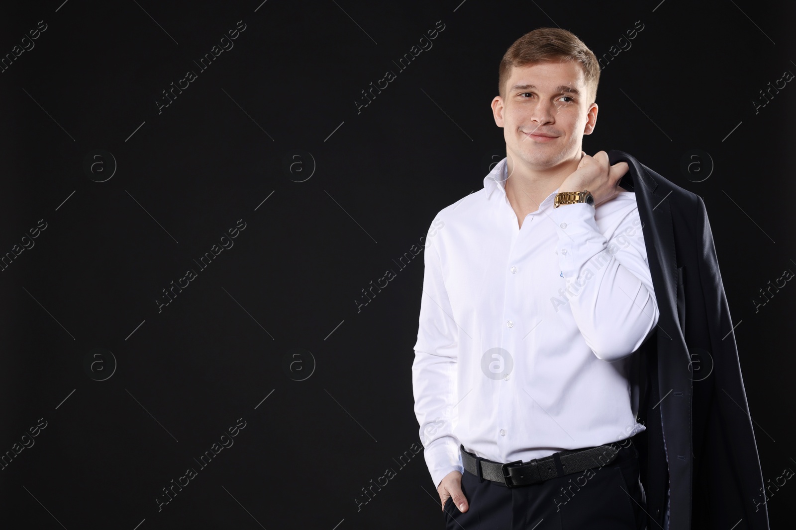 Photo of Man in classic suit on black background. Space for text