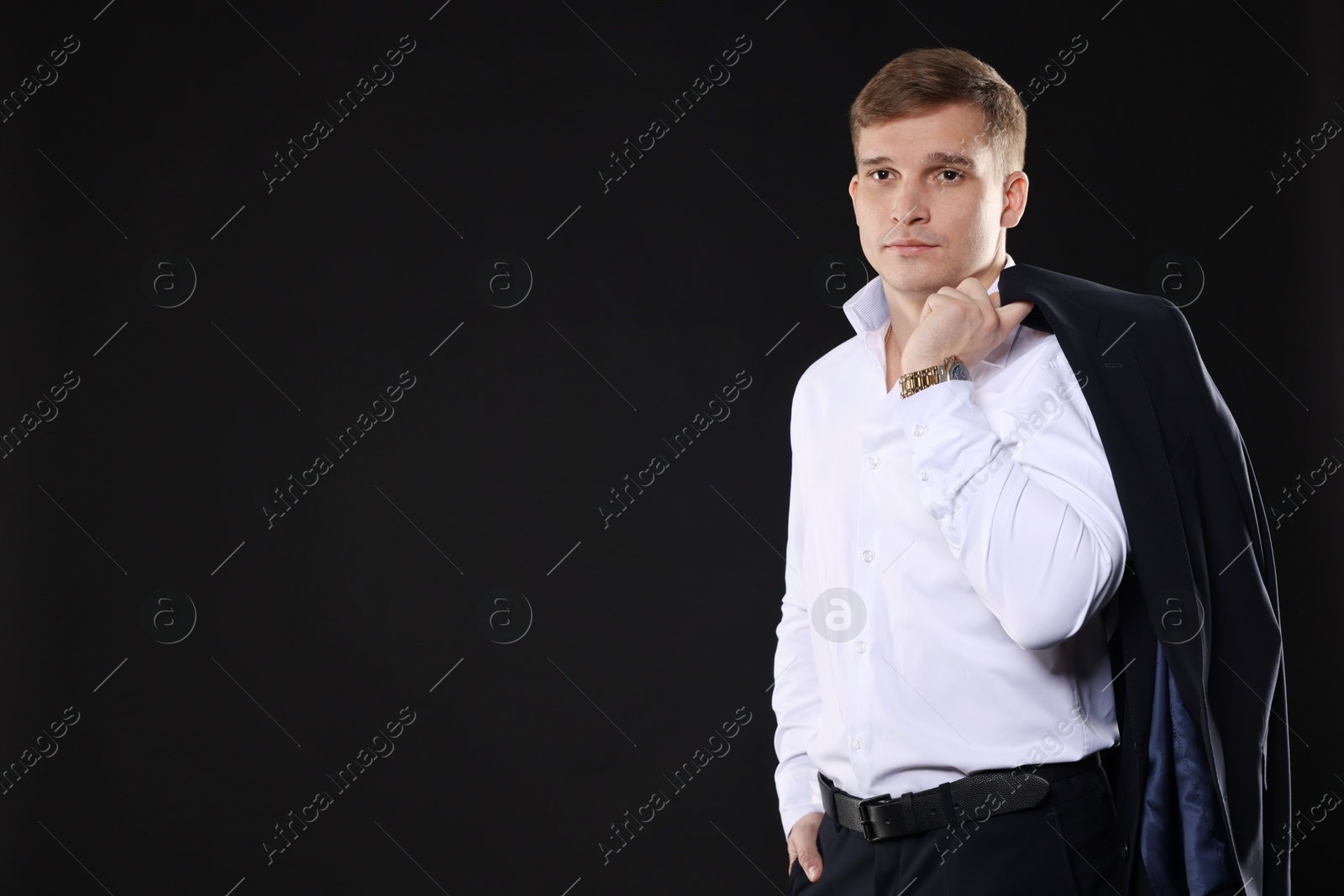 Photo of Man in classic suit on black background. Space for text