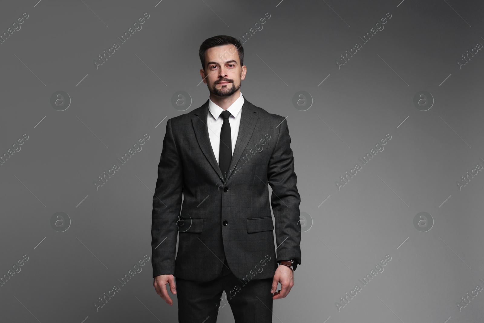 Photo of Confident man in classic suit on grey background