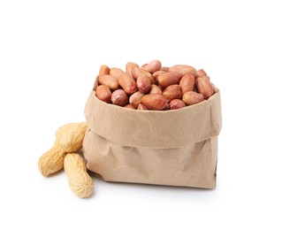 Photo of Fresh peanuts in paper bag and unpeeled ones isolated on white