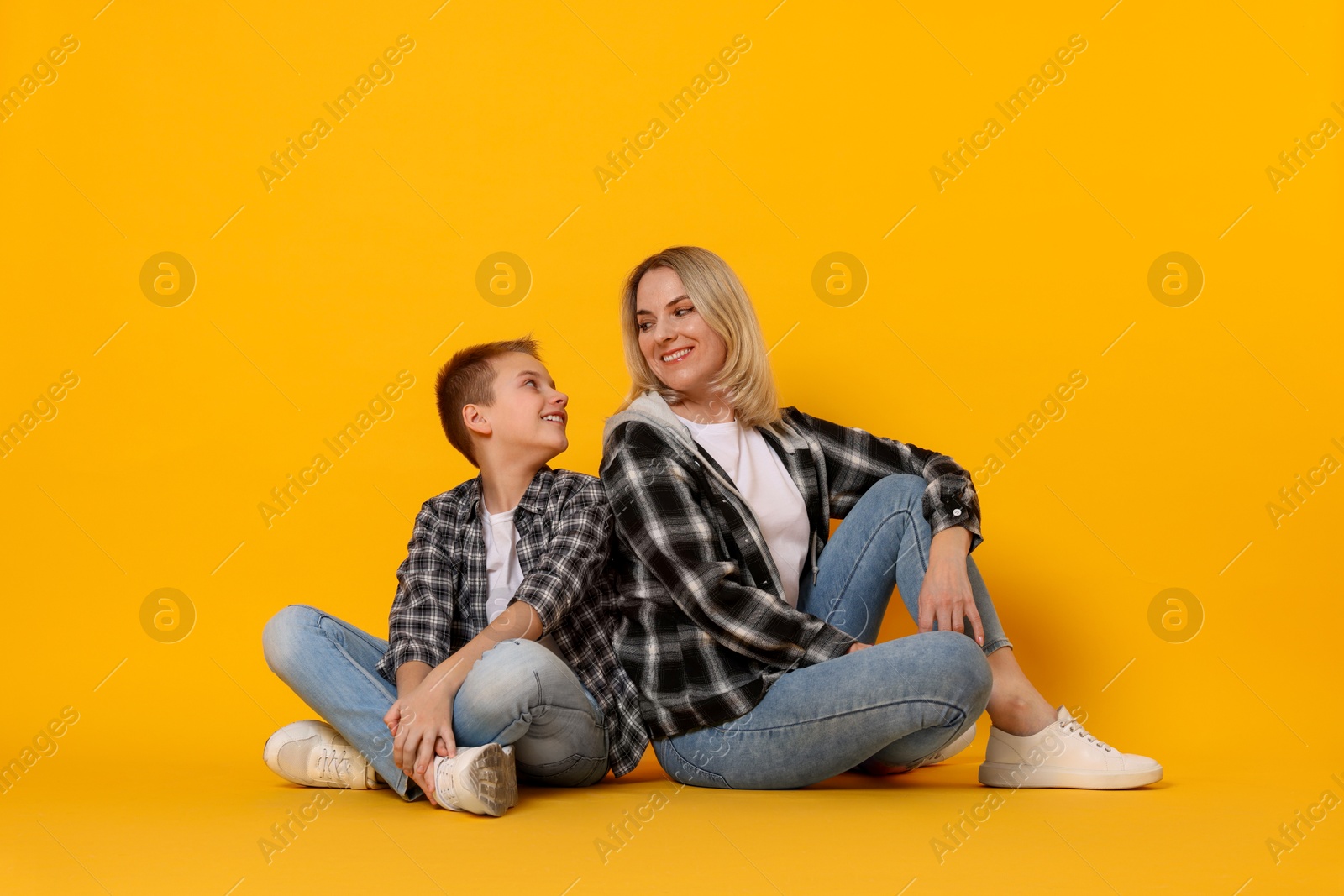 Photo of Happy mother and son on orange background