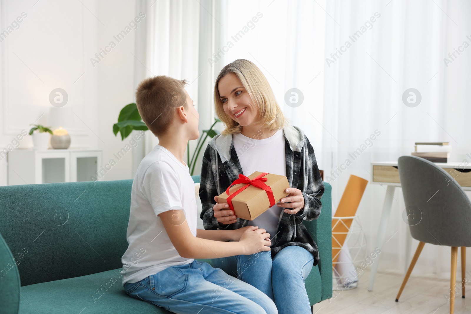 Photo of Son giving present to his mom at home