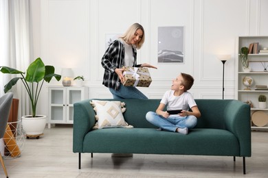 Photo of Mother giving present to her son at home