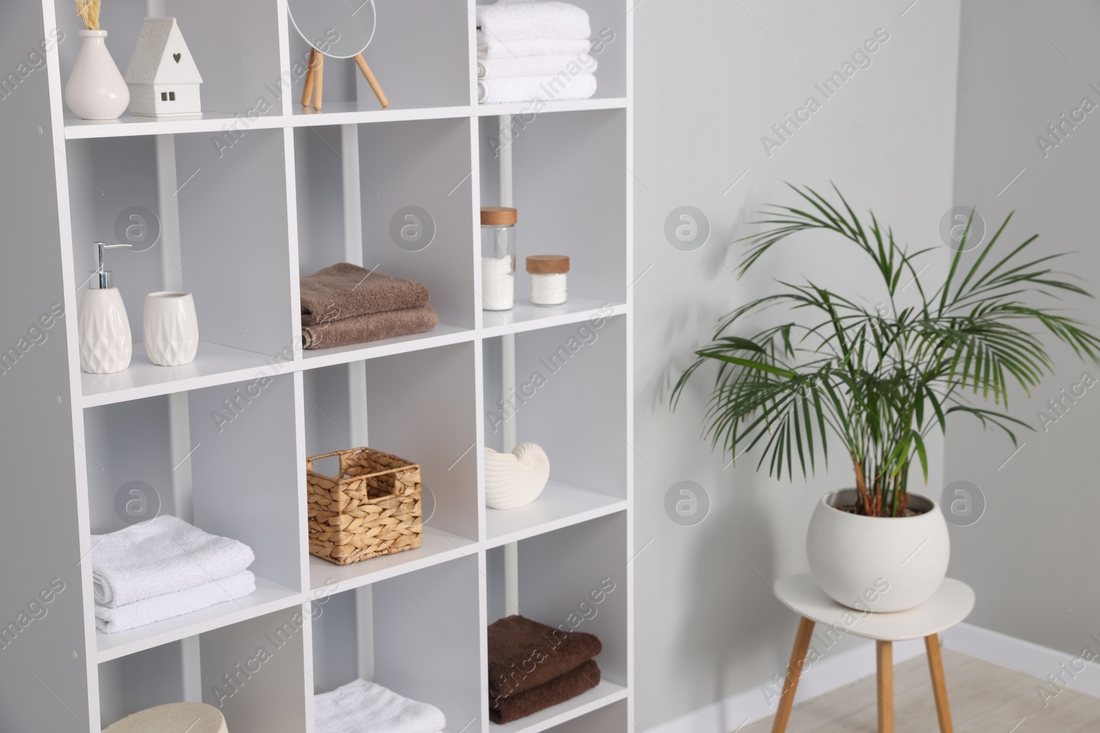 Photo of Shelving unit with decor near light grey wall