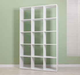 Photo of Empty shelving unit near olive wall indoors