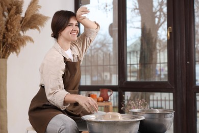 Photo of Hobby and craft. Smiling woman making pottery indoors