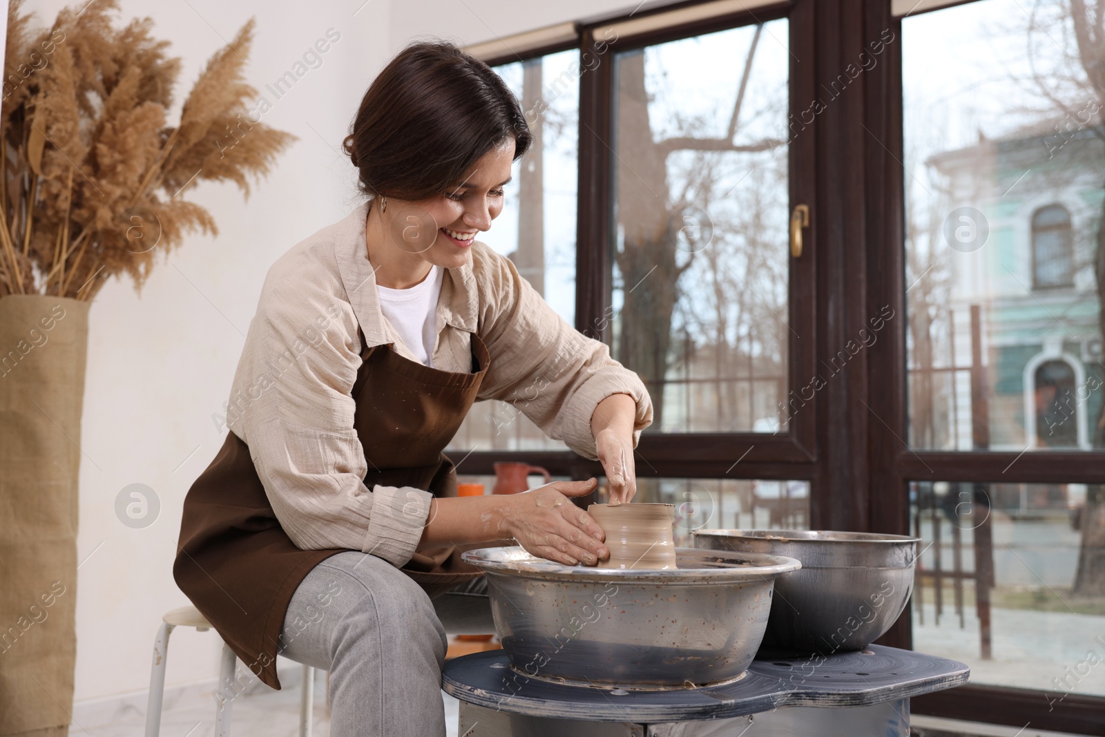 Photo of Hobby and craft. Smiling woman making pottery indoors