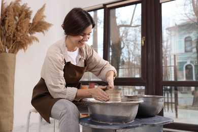 Photo of Hobby and craft. Smiling woman making pottery indoors