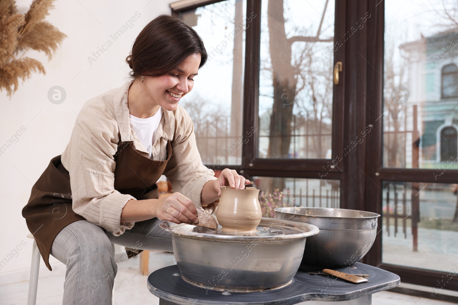 Photo of Hobby and craft. Smiling woman making pottery indoors