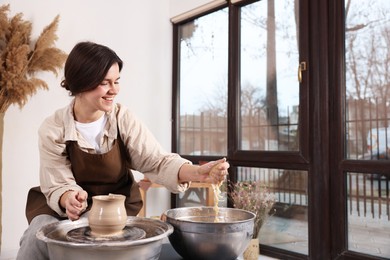 Hobby and craft. Smiling woman making pottery indoors