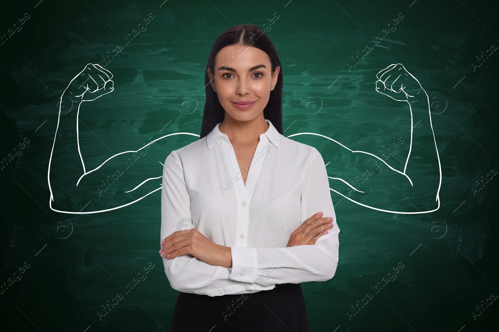 Image of Confident woman with drawing of strong arms behind her on green chalkboard