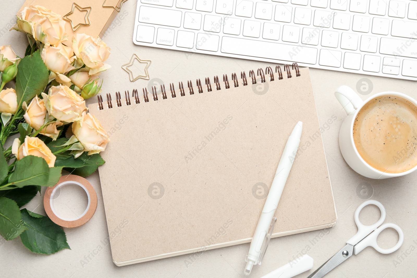 Photo of Paper clips, other stationery, coffee, computer keyboard and roses on light grey background, flat lay