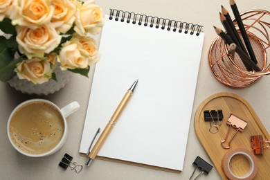 Photo of Binder clips, other stationery, coffee and roses on light grey background, flat lay