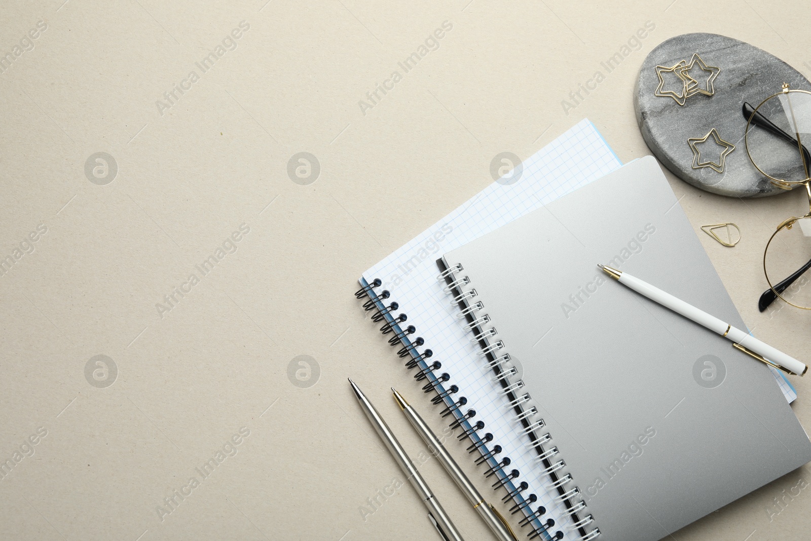 Photo of Paper clips, other stationery and glasses on light grey background, flat lay. Space for text