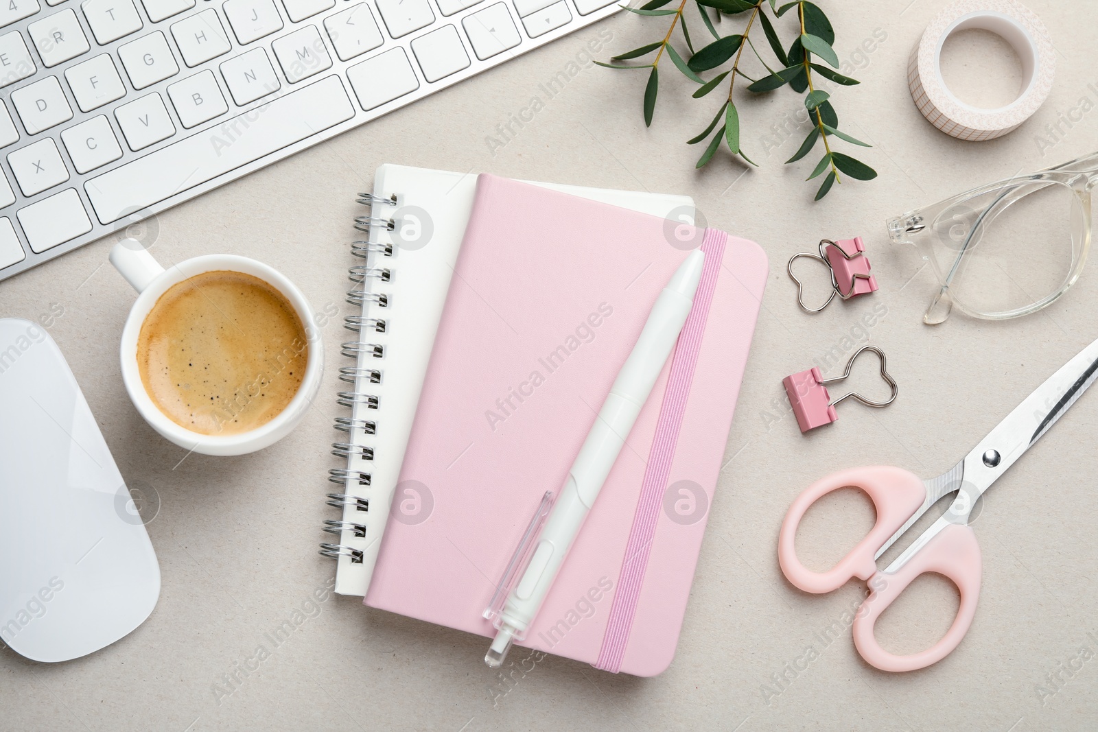 Photo of Binder clips, other stationery, coffee, computer keyboard, mouse and green branches light grey background, flat lay