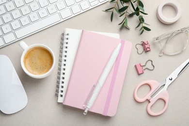 Binder clips, other stationery, coffee, computer keyboard, mouse and green branches light grey background, flat lay