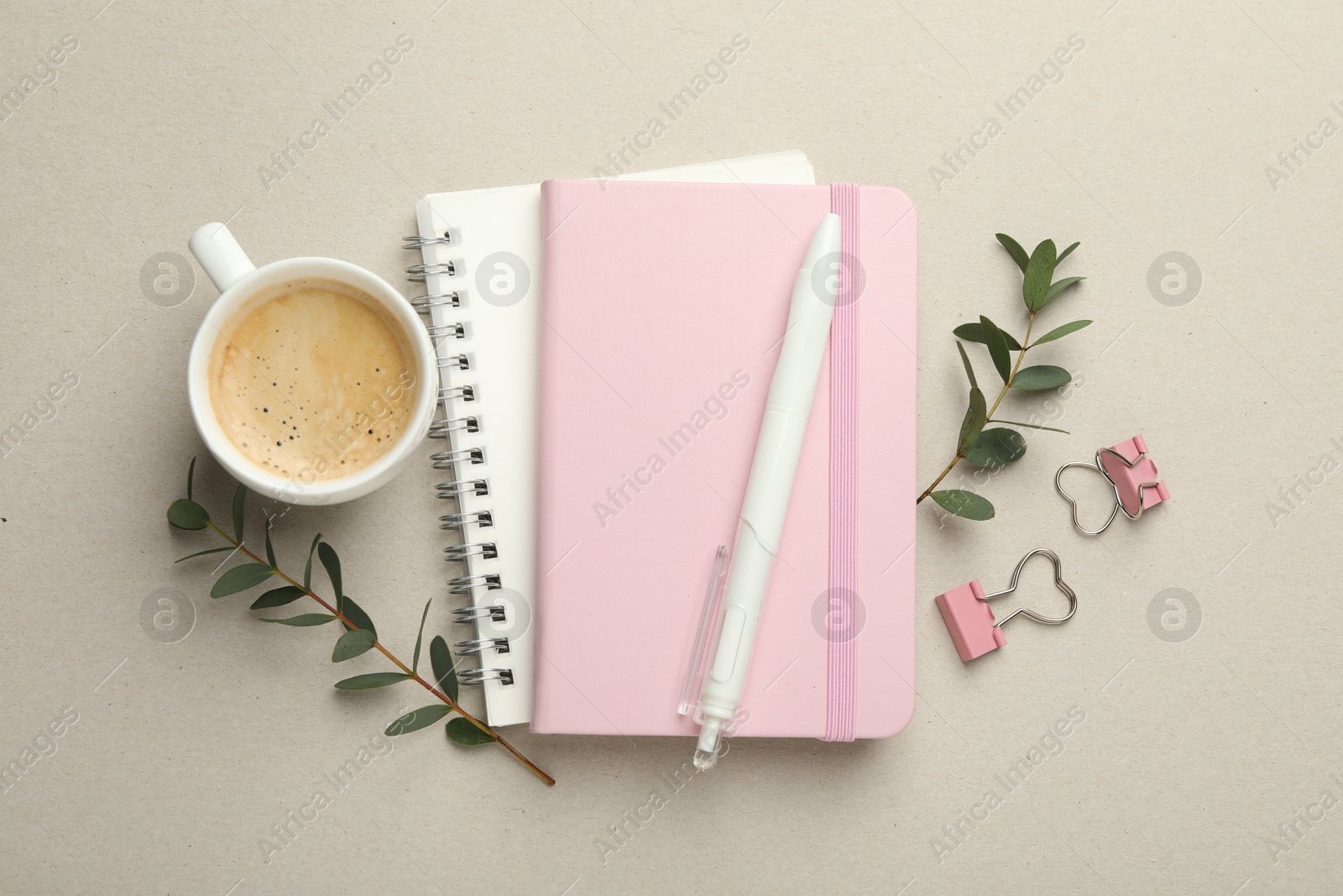 Photo of Binder clips, other stationery, coffee and green branches light grey background, flat lay