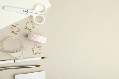 Photo of Paper clips, other stationery and glasses on light grey background, flat lay. Space for text