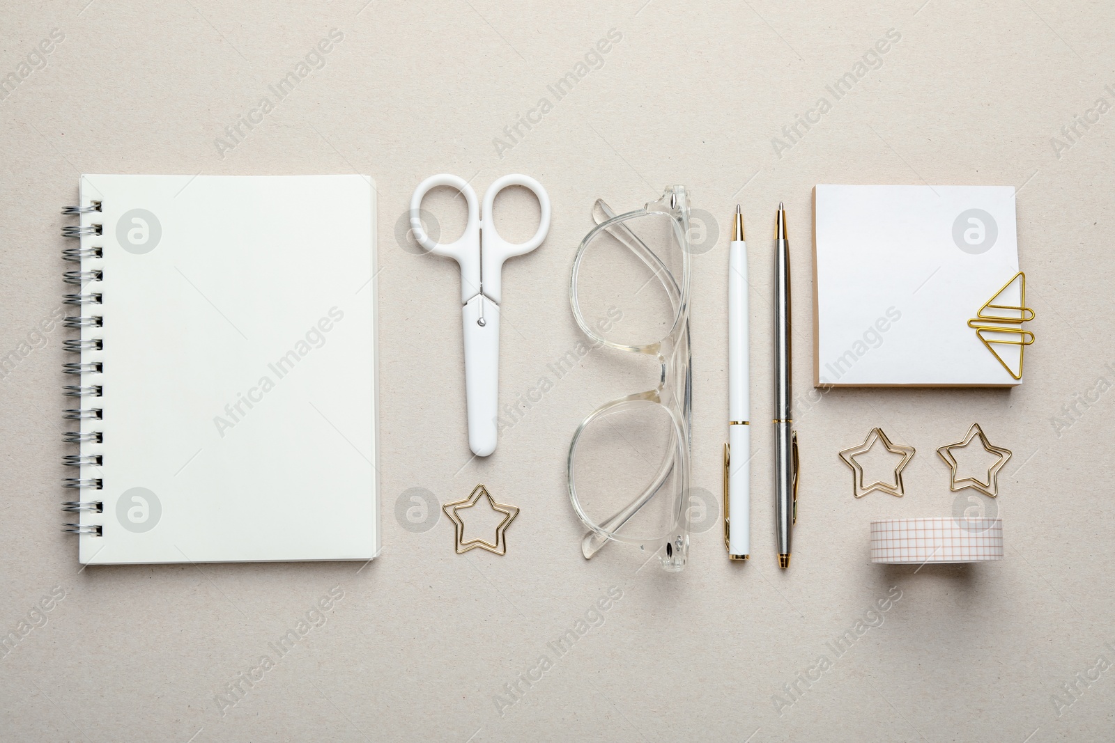 Photo of Paper clips, other stationery and glasses on light grey background, flat lay