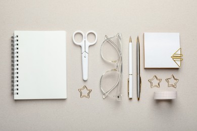 Paper clips, other stationery and glasses on light grey background, flat lay