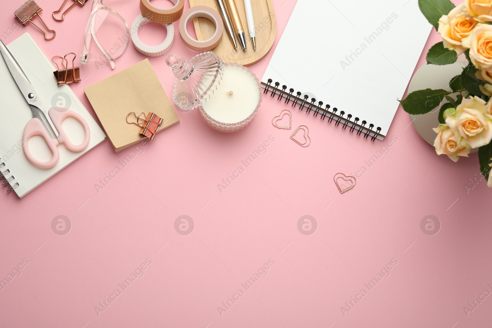 Photo of Paper clips, other stationery and decor on pink background, flat lay. Space for text