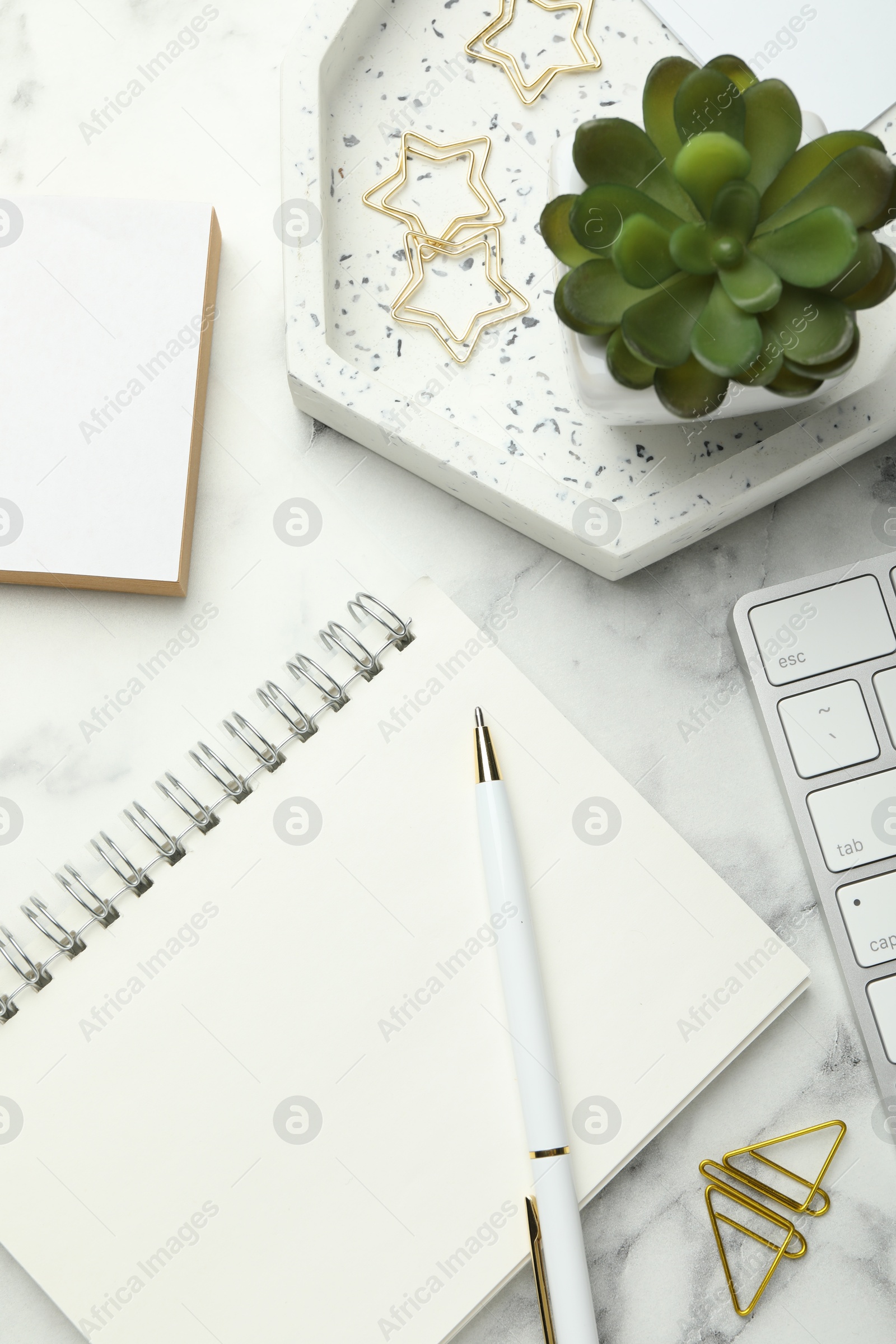 Photo of Paper clips, other stationery and decor on white marble table, flat lay