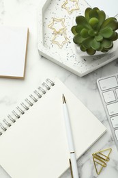 Paper clips, other stationery and decor on white marble table, flat lay