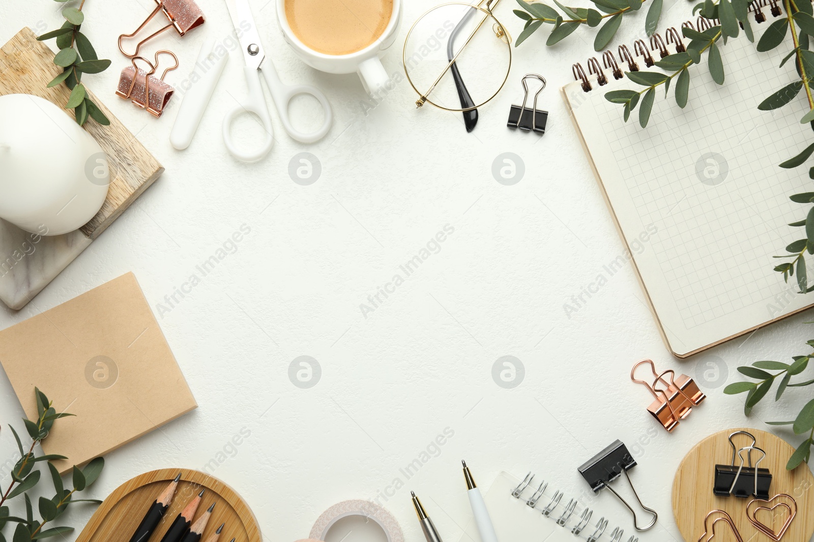 Photo of Frame of paper clips, other stationery, coffee and green branches on white background, flat lay. Space for text