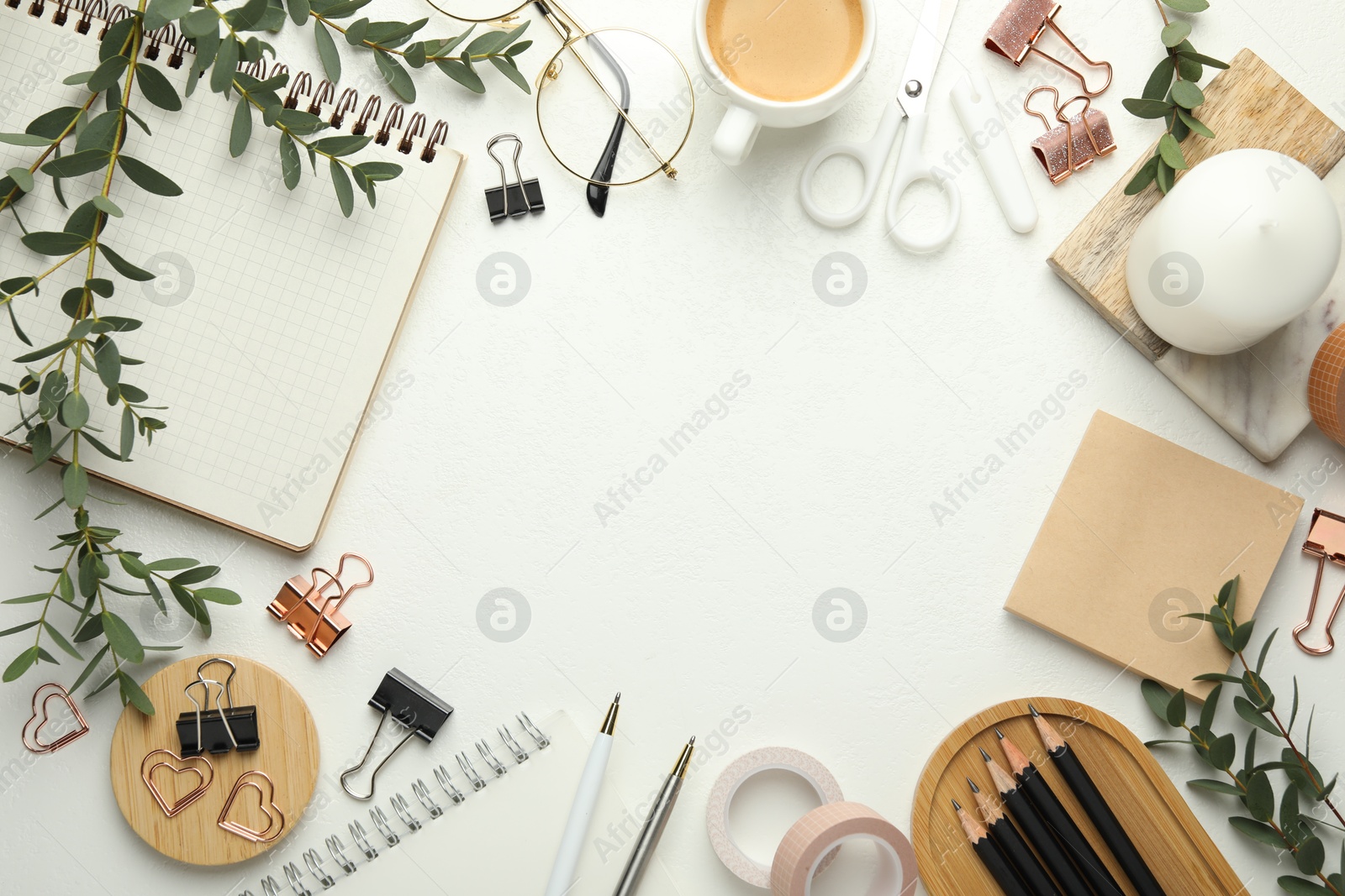 Photo of Frame of paper clips, other stationery, coffee and green branches on white background, flat lay. Space for text