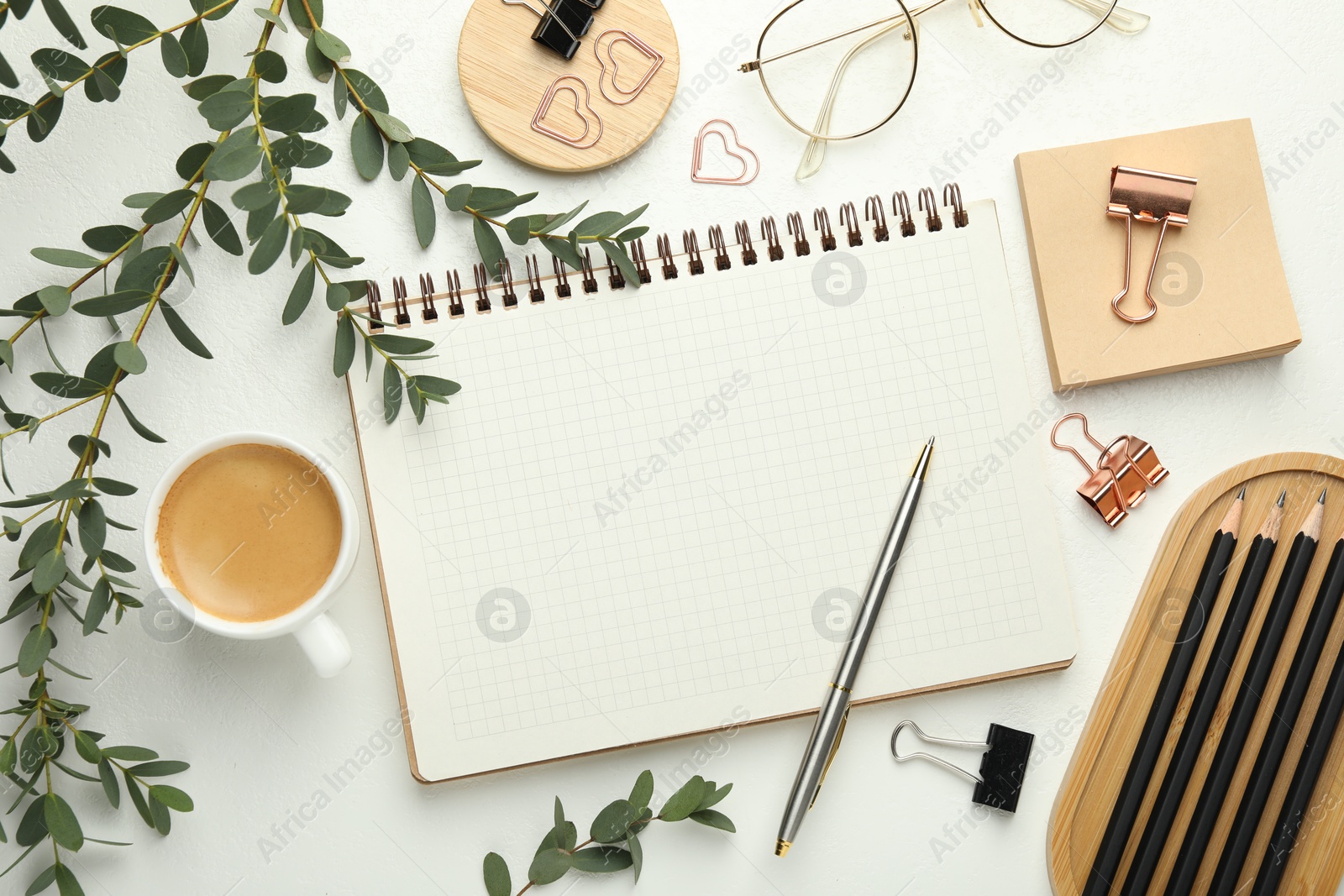 Photo of Paper clips, other stationery, coffee and green branches on white background, flat lay