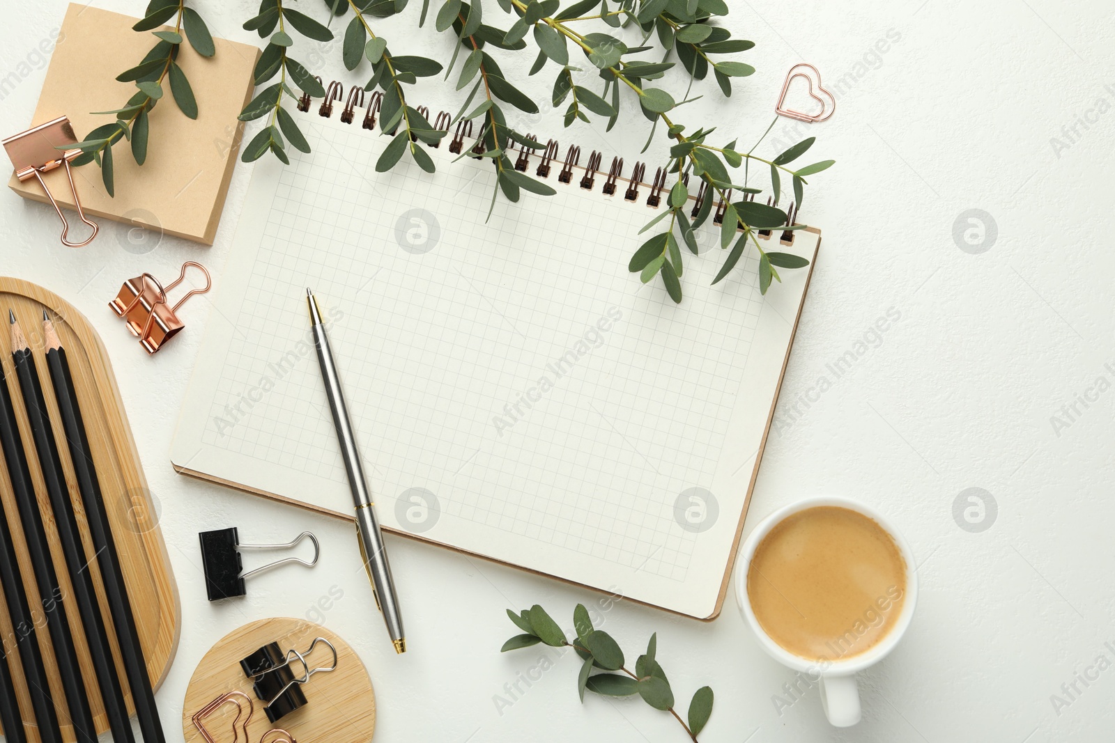 Photo of Paper clips, other stationery, coffee and green branches on white background, flat lay