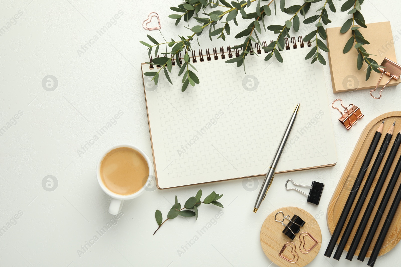 Photo of Paper clips, other stationery, coffee and green branches on white background, flat lay. Space for text