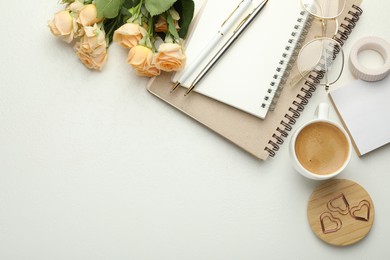 Paper clips, other stationery, coffee, glasses and roses on white background, flat lay. Space for text