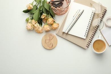 Paper clips, other stationery, coffee, glasses and roses on white background, flat lay. Space for text