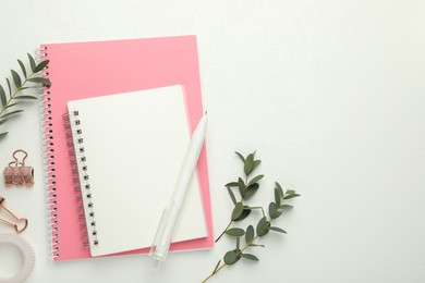 Photo of Binder clips, other stationery and green branches on white background, flat lay. Space for text