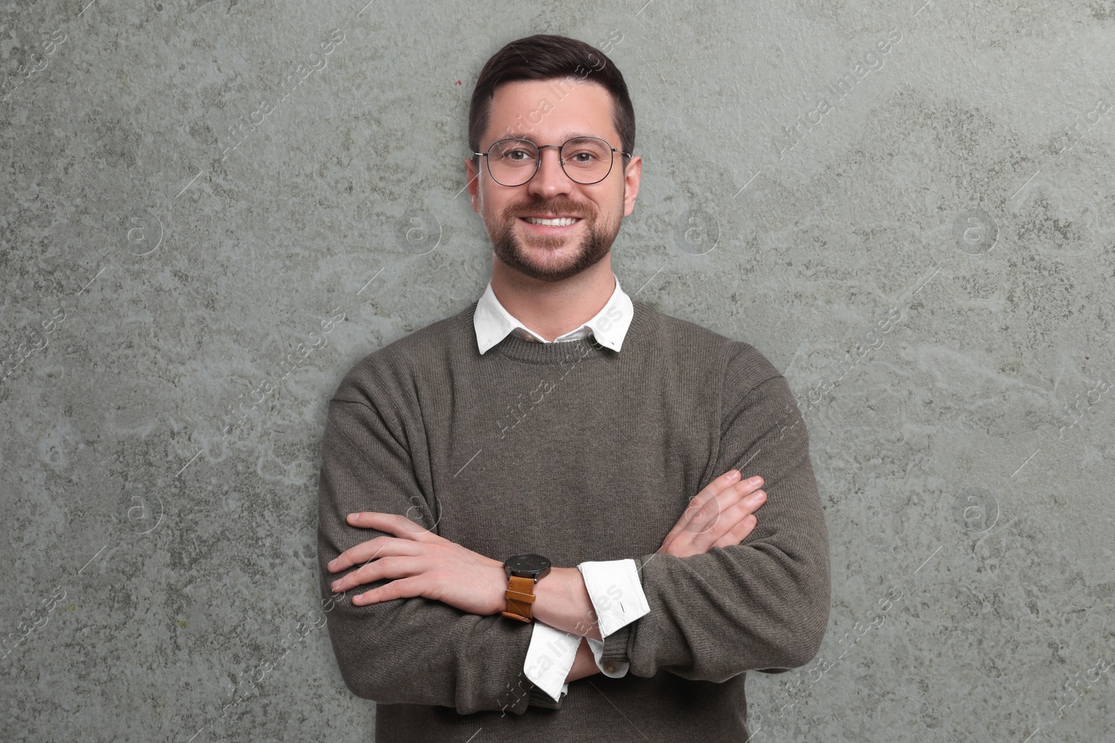 Image of Portrait of handsome bearded businessman in eyeglasses on grey textured background