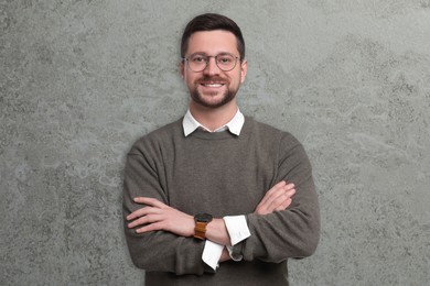 Portrait of handsome bearded businessman in eyeglasses on grey textured background