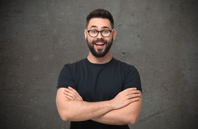 Portrait of happy young man on grey textured background