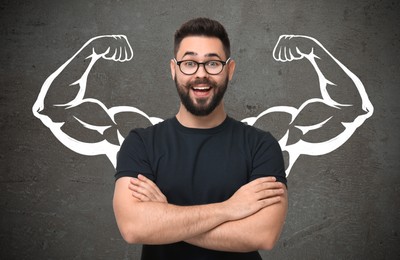 Image of Happy man with drawing of strong arms behind him on grey background