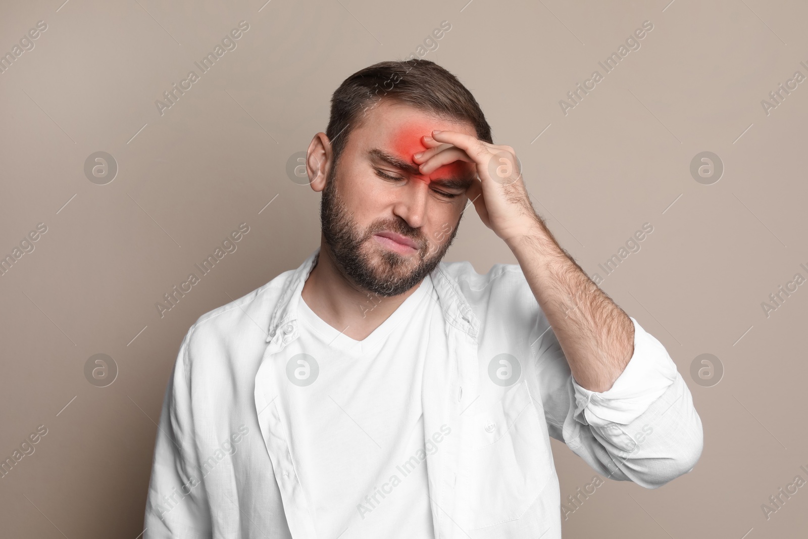 Image of Man suffering from headache on beige background